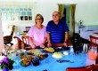Os proprietários do Sítio Sonho Meu e a mesa de café colonial oferecido aos hóspedes e visitantes
